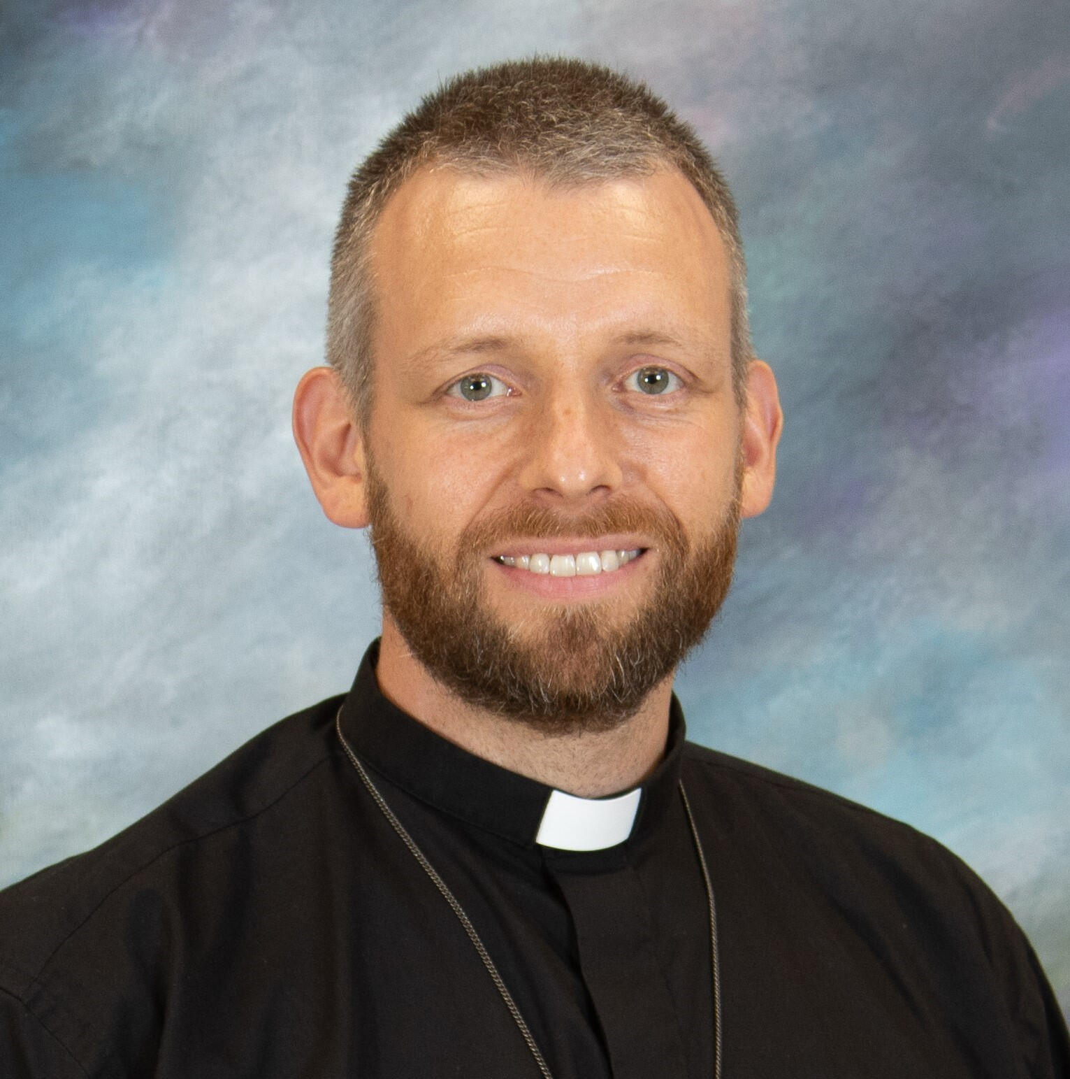 Middle-aged man in clerical collar: Rev. Carl Petzold, pastor of Hope Lutheran Church in St. Helen, MI.